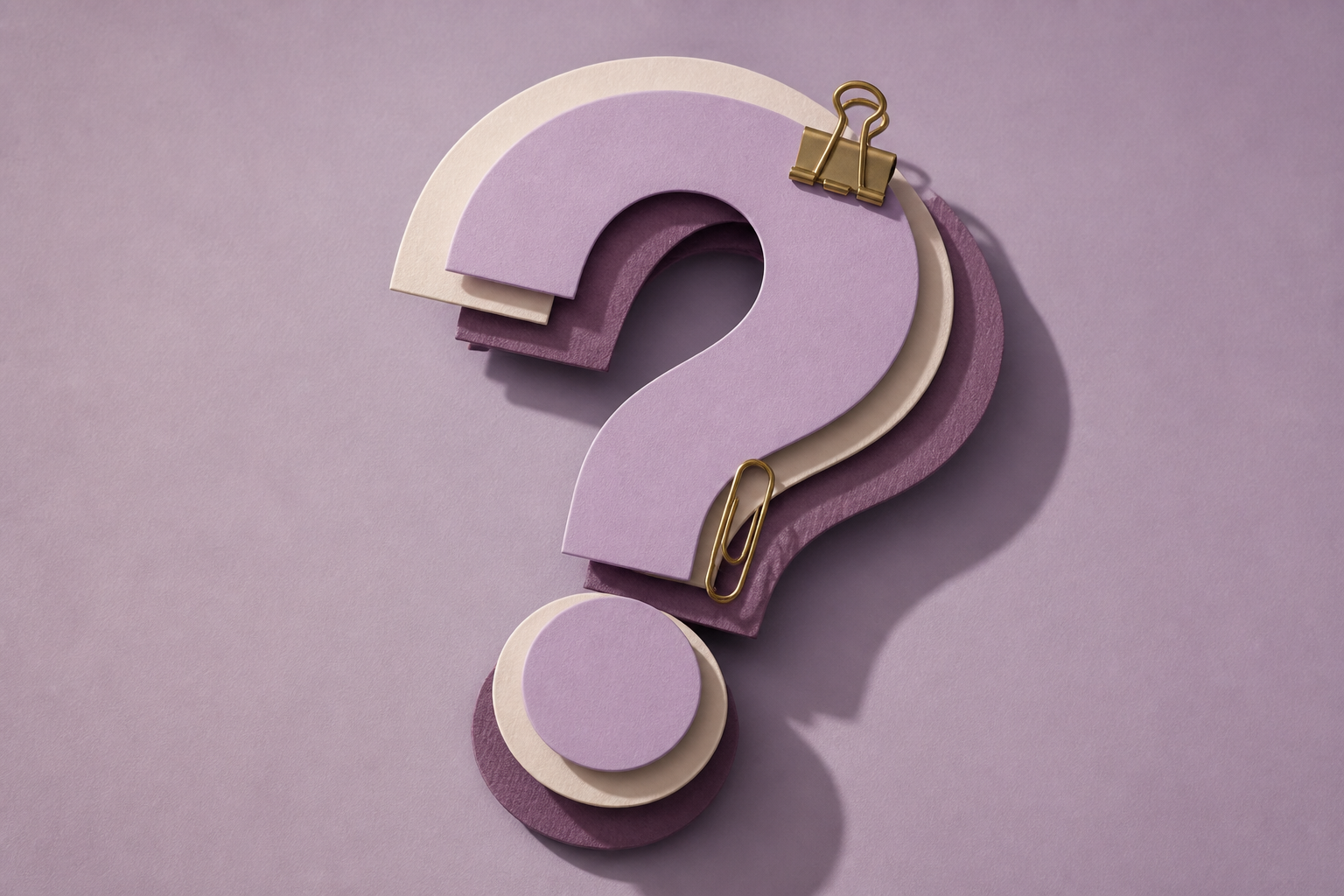 Paper question-mark shapes with brass clips on a lavender desk